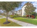 Landscaped home on a tree-lined street with sidewalk at 28475 Marsciano Ln, Wesley Chapel, FL 33543