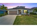 Two-story house with gray siding, landscaping, and a welcoming front porch at 3322 Woodmont Dr, Parrish, FL 34219