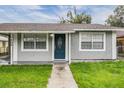 Newly painted gray house with blue front door at 3409 E Comanche Ave, Tampa, FL 33610