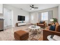 Living room with hardwood floors, staged furniture, and large TV at 3409 E Comanche Ave, Tampa, FL 33610