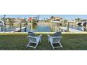 Two white Adirondack chairs overlooking a calm canal at 380 137Th Avenue Cir, Madeira Beach, FL 33708