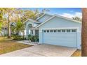 The home features a light blue exterior, two-car garage, and landscaping at 14721 Condor Pass, Clearwater, FL 33760
