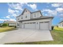 Two-story house with gray siding, three-car garage, and landscaping at 2436 Sand Gables Trl, Bradenton, FL 34208