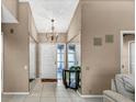 Bright entryway with mirrored walls, chandelier, and tile flooring at 3028 Summervale Dr, Holiday, FL 34691