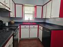 Retro kitchen features red cabinets, black countertops, and classic appliances at 908 N Gordon St, Plant City, FL 33563