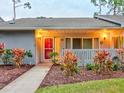 Gray condo with red door, walkway, and landscaping at dusk at 10 Aster Pl, Oldsmar, FL 34677