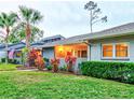 Gray condo with red door, walkway, landscaping, and palm trees at dusk at 10 Aster Pl, Oldsmar, FL 34677