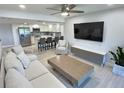 Open living area with modern furnishings, a kitchen island, and a large TV at 1001 S Bayshore Blvd # 205, Safety Harbor, FL 34695