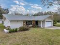 Ranch-style home with stone accents and a well-maintained lawn at 1559 Glengarry Dr, Palm Harbor, FL 34684