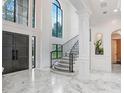 Elegant two-story foyer with marble floors, a grand staircase, and a stunning chandelier at 16220 Villarreal De Avila, Tampa, FL 33613