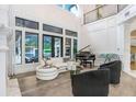 Open living area featuring a white sofa, black armchairs, and a grand piano at 16220 Villarreal De Avila, Tampa, FL 33613