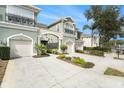 Townhome with two-car garage, landscaping, and inviting entryway at 2135 Park Crescent Dr, Land O Lakes, FL 34639