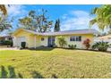 Bright yellow house with a neatly landscaped yard at 2589 Redwood Cir, Clearwater, FL 33763