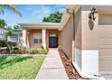 Front entrance with walkway, landscaping, and two dark-colored doors at 2715 Durant Trails Blvd, Dover, FL 33527