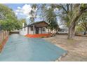 Charming house with a teal driveway and large trees at 3020 Deleuil Ave, Tampa, FL 33610