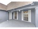 Covered front porch featuring neutral paint and large windows with white shutters at 3205 Moog Rd, Holiday, FL 34691