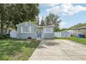 Gray house with stone accents, a large yard, and a white fence at 6108 Pershing Ne St, St Petersburg, FL 33703