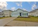 Front view of a single-story house with a light blue exterior and a two-car garage at 11520 Koti Creek Ln, Thonotosassa, FL 33592