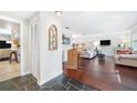 Open living area with hardwood floors, stone entryway, and built-in bar at 1230 Nelson St, Dunedin, FL 34698