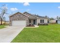 House exterior showcasing stone accents, a two-car garage, and a lush lawn at 15171 Pomp Parkway, Weeki Wachee, FL 34614