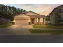 House exterior at dusk with a two-car garage and porch at 15579 Stone House Dr, Brooksville, FL 34604