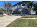 Contemporary home with gray siding, three car garage, and landscaped lawn at 1600 Pennsylvania Ne Ave, St Petersburg, FL 33703