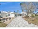 Side view of a light teal home with a paved walkway leading to the house and patio at 17602 Sterling Ter, Redington Shores, FL 33708