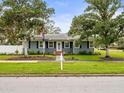 Gray sided ranch home with lush landscaping and American flag at 320 N Madison Ave, Clearwater, FL 33755