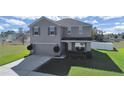 Two-story house with gray siding, brown accents, and a two-car garage at 4179 Bramblewood Loop, Spring Hill, FL 34609