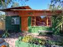 Charming green and orange one-story home featuring colorful accents and a cozy front patio at 5209 10Th S Ave, Gulfport, FL 33707