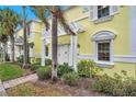 Exterior of light yellow building with walkway, lush landscaping, and pergola at 5258 Beach Se Dr, St Petersburg, FL 33705