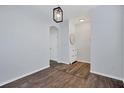 Inviting entryway featuring hardwood floors, neutral walls, and modern light fixture at 7041 Spotted Deer Pl, Riverview, FL 33569