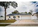 Updated single story home with a white exterior, landscaped lawn, and attached garage at 7097 Aberfeldy N Ave, St Petersburg, FL 33709