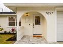 Inviting front entry with arched entryway, updated door, and decorative tile at 7097 Aberfeldy N Ave, St Petersburg, FL 33709