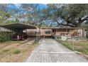 Mobile home with carport, paved driveway, and large shade trees at 7401 Mount Vernon Rd, Tampa, FL 33625