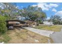 Mobile home with carport, paved driveway, and large shade trees at 7401 Mount Vernon Rd, Tampa, FL 33625