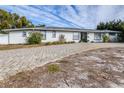 House exterior featuring a paver driveway and well-manicured lawn at 7601 9Th N Ave, St Petersburg, FL 33710