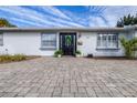 Stylish front entrance with black door and stone pavers at 7601 9Th N Ave, St Petersburg, FL 33710