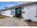 Home's front entry with black door, wreath, and stone walkway at 7601 9Th N Ave, St Petersburg, FL 33710