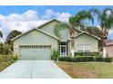 One-story house with light green walls and palm trees at 9516 Cypress Harbor Dr, Gibsonton, FL 33534