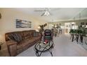 Living room with brown leather sofa, armchair, and glass coffee table at 124 W Cypress Ct, Oldsmar, FL 34677