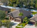 Aerial view of home featuring a screened in pool, well manicured lawn, and two car garage at 1525 Banner Elk St, Valrico, FL 33594