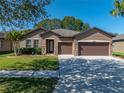 Well-maintained single-Gathering home with a manicured lawn, attractive landscaping, and a two-car garage at 1525 Banner Elk St, Valrico, FL 33594