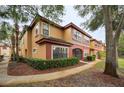 Two-story condo building with a yellow and red exterior and lush landscaping at 2254 Chianti Pl # 68, Palm Harbor, FL 34683