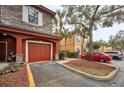 Attached garage with red door and landscaping, in a community setting at 2254 Chianti Pl # 68, Palm Harbor, FL 34683