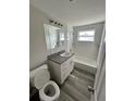 Renovated bathroom with new vanity, tub, and flooring at 3341 Wiltshire Dr, Holiday, FL 34691