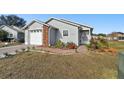 Gray house with brick accents, attached garage, and landscaped front yard at 37401 Wedgewood Dr, Zephyrhills, FL 33542