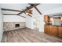 Open living room space featuring wood flooring, stone fireplace, and beamed ceilings at 435 Laughing Gull Ln, Palm Harbor, FL 34683