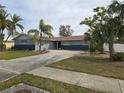 Newly painted ranch home with a long driveway and palm trees at 4701 Lodestone Dr, Tampa, FL 33615