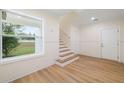 Light-filled entryway, showcasing a staircase and wood-look floors at 4829 Jenny Way, New Port Richey, FL 34652